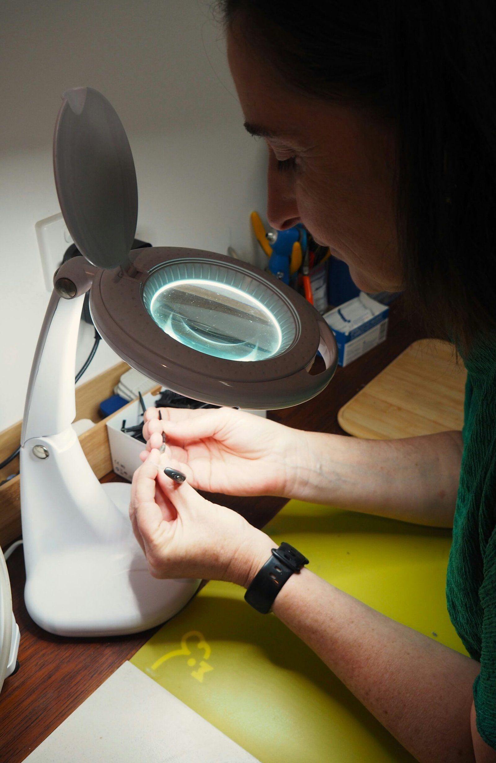 A woman sitting at a table with a magnifying glass